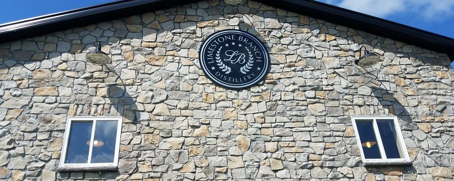 Stone building facade with two windows and a circular emblem centered near the roofline