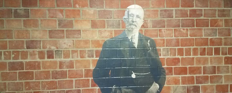 Black-and-white figure on a brick wall mural with a faint grid overlay