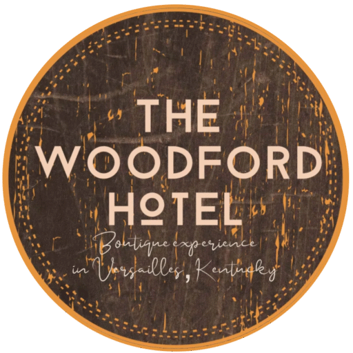 Round wooden sign for The Woodford Hotel, with worn dark brown background and beige lettering.