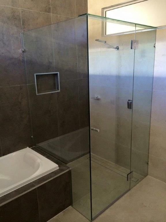 A Bathroom With A Walk In Shower And A Bathtub — Frameless Shower Installations In Maroochydore, QLD