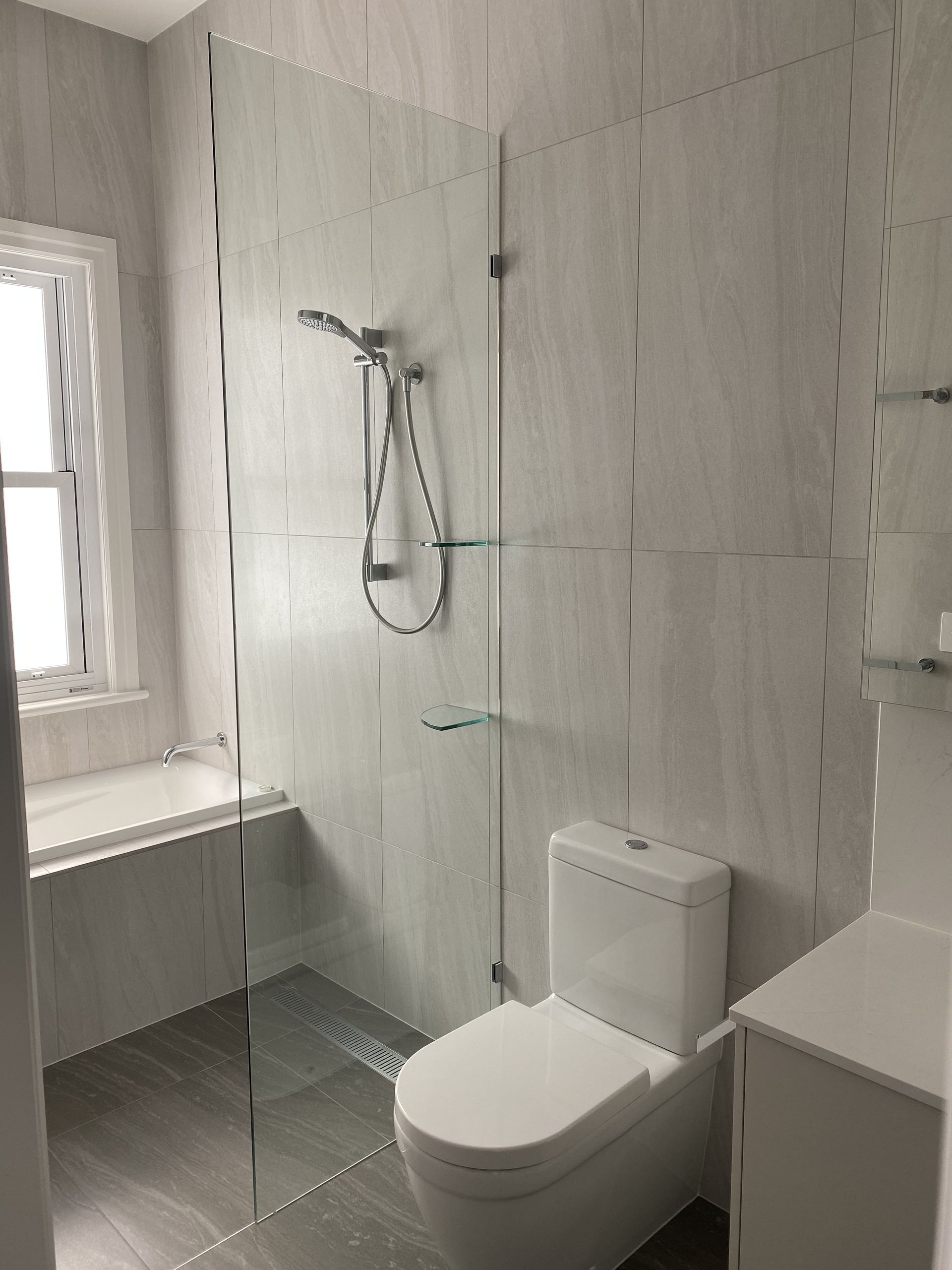 A Bathroom With a Walk in Shower and a Toilet — Frameless Shower Installations in Maroochydore, QLD 