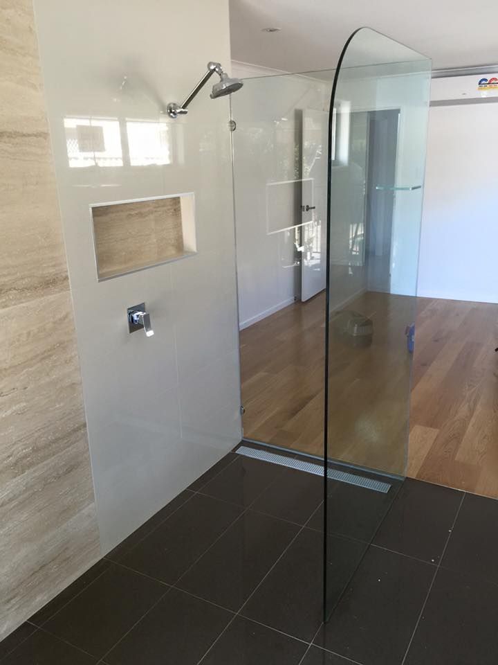 A Bathroom With a Walk in Shower and a Shower Head — Frameless Shower Installations in Maroochydore, QLD