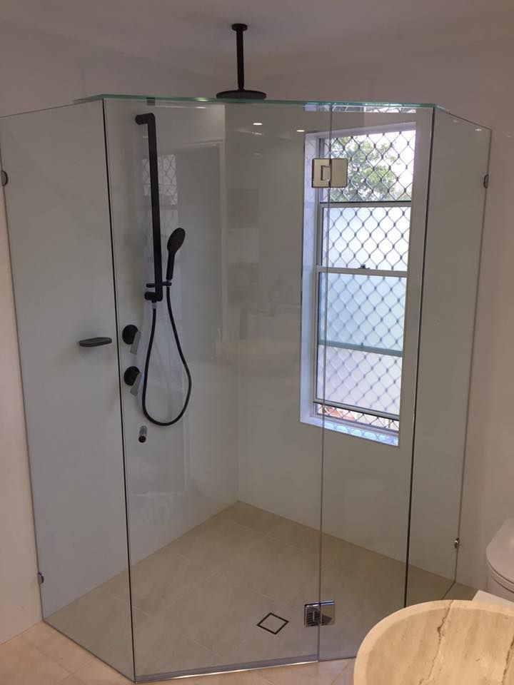 A Bathroom With a Shower Stall and a Window — Frameless Shower Installations In Caloundra, QLD