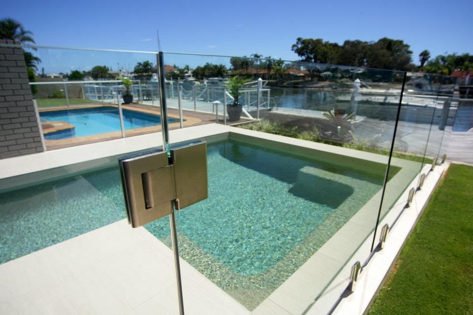 A Swimming Pool With A Glass Fence Around It — Frameless Shower Installations, Sunshine Coast