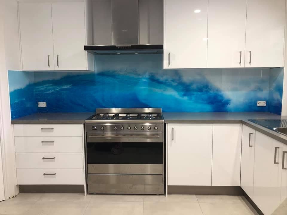 Kitchen with a blue glass splashback behind the stove — Frameless Shower Installations, Sunshine Coast.