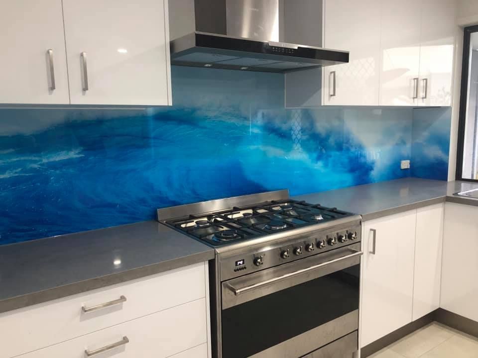 A Kitchen With a Stove, Oven, Cabinets and a Painting on the Wall — Frameless Shower Installations In Maroochydore, QLD