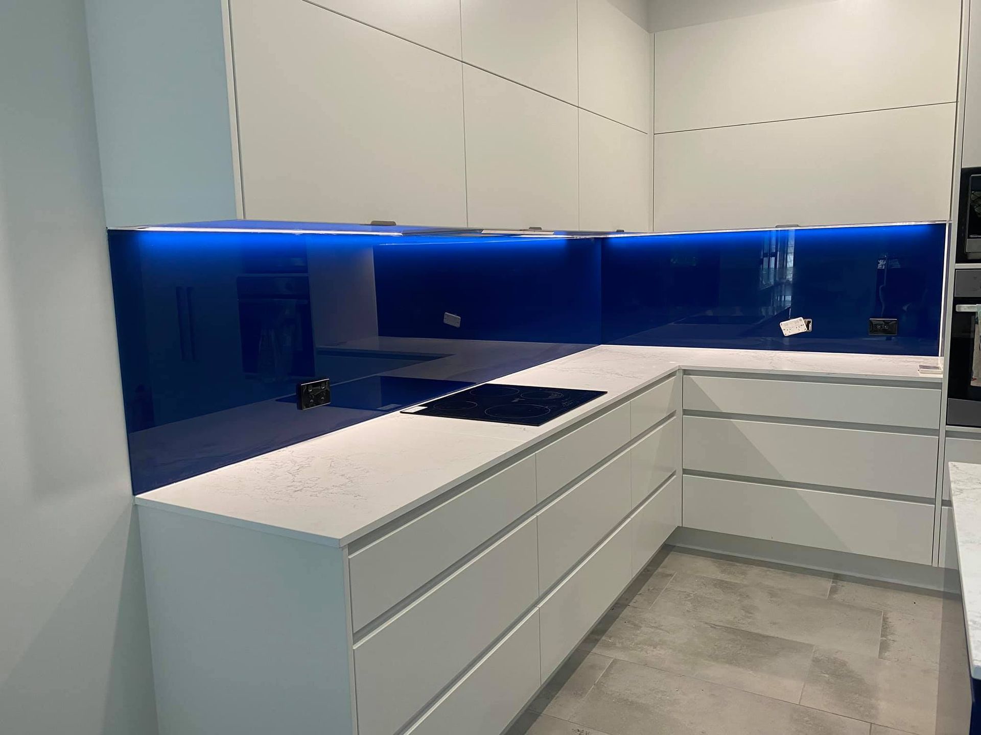 A Kitchen With White Cabinets and a Blue Counter Top — Frameless Shower Installations In Mooloolaba, QLD