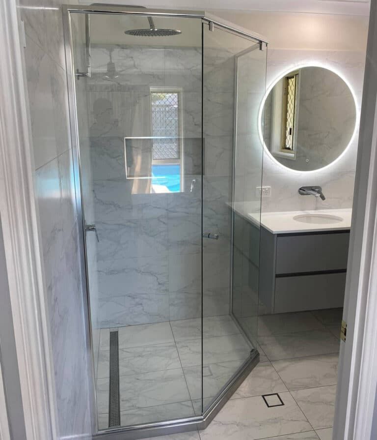 A Bathroom With A Shower, Sink And Mirror — Frameless Shower Installations In Maroochydore, QLD