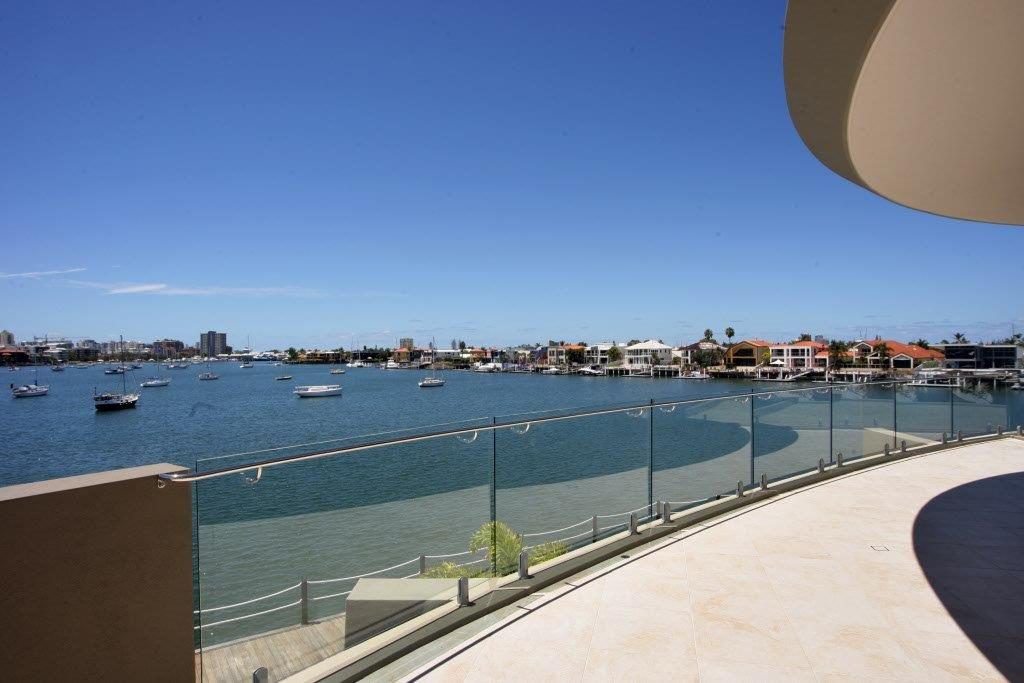 A Balcony Overlooking a Body of Water With Boats in It — Frameless Shower Installations In Maroochydore, QLD
