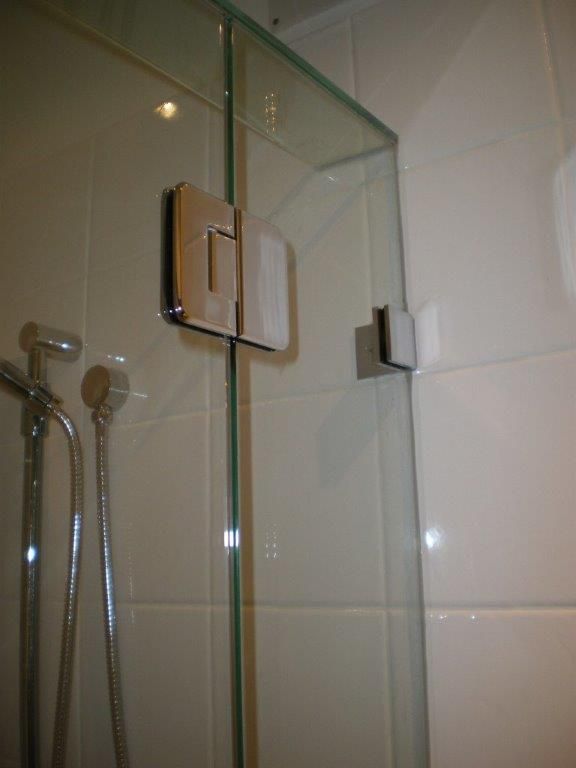 A Bathroom With a Glass Shower Door and a Shower Head — Frameless Shower Installations In Maroochydore, QLD