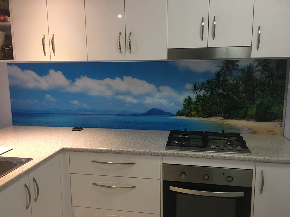 Kitchen with White Cabinets, a Beach Scene Backsplash, and a Stove — Frameless Shower Installations In Maroochydore, QLD