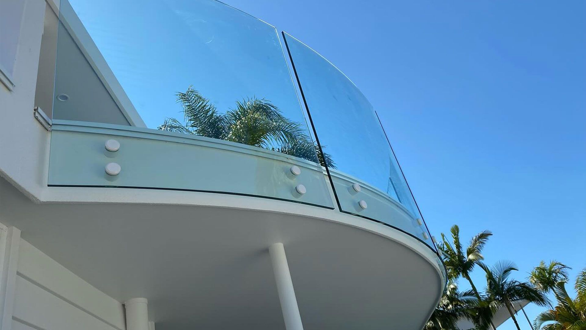 A Balcony With a Glass Railing on the Side of a Building — Frameless Shower Installations In Maroochydore, QLD