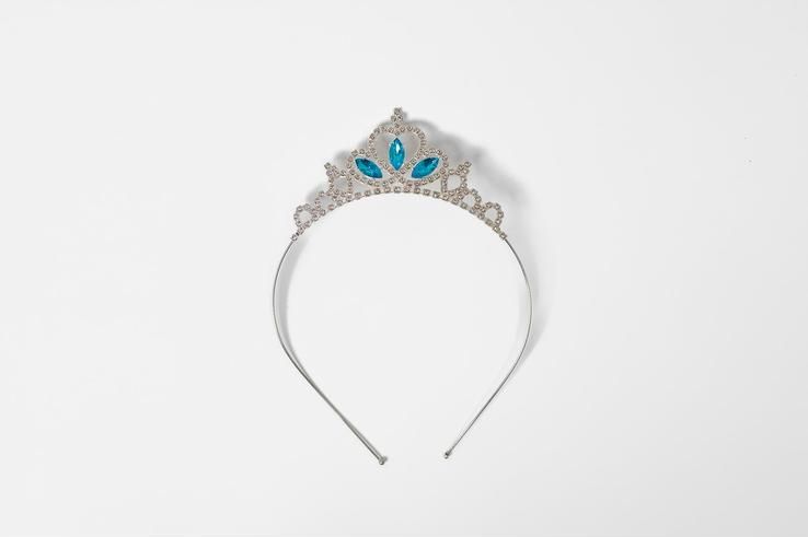 A silver tiara with blue stones on a white background.