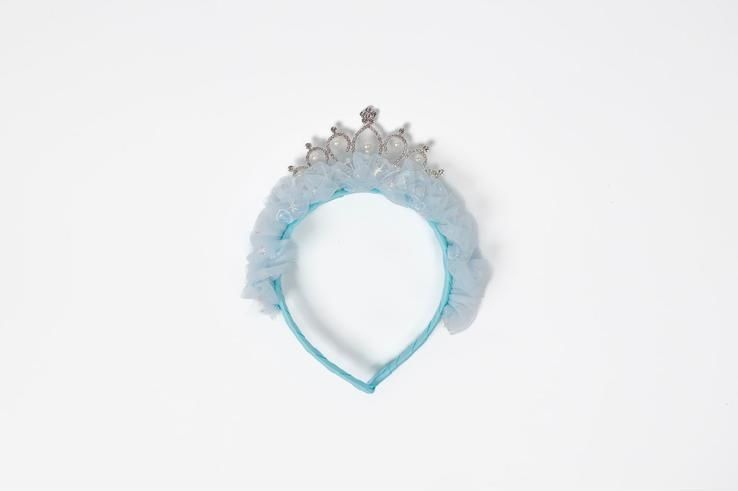 A blue headband with a tiara on it on a white background.
