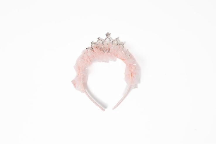 A pink headband with a crown on it on a white background.