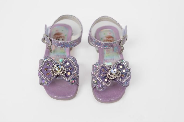 A pair of purple sandals with a bow on them