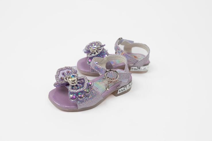 A pair of purple sandals with a bow on them