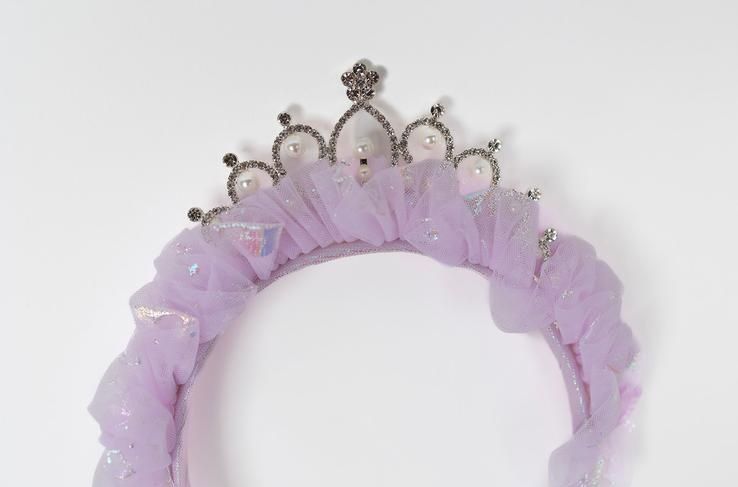 A purple headband with a crown on it on a white background.