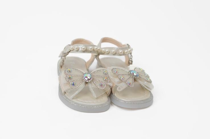 A pair of white shoes with rhinestones on a white background.