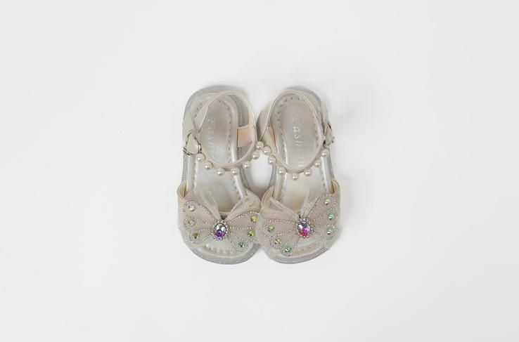 A pair of white shoes with rhinestones on a white background.
