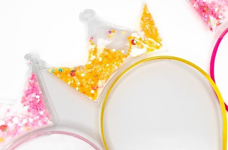 A close up of three headbands in the shape of a crown on a white background.