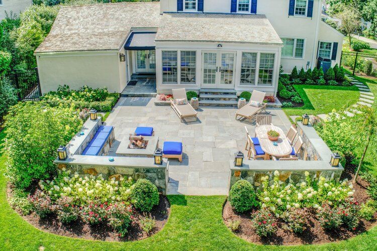 Davida Landscape Designs owner shaking hands with a Fairfield County homeowner outside a brick house