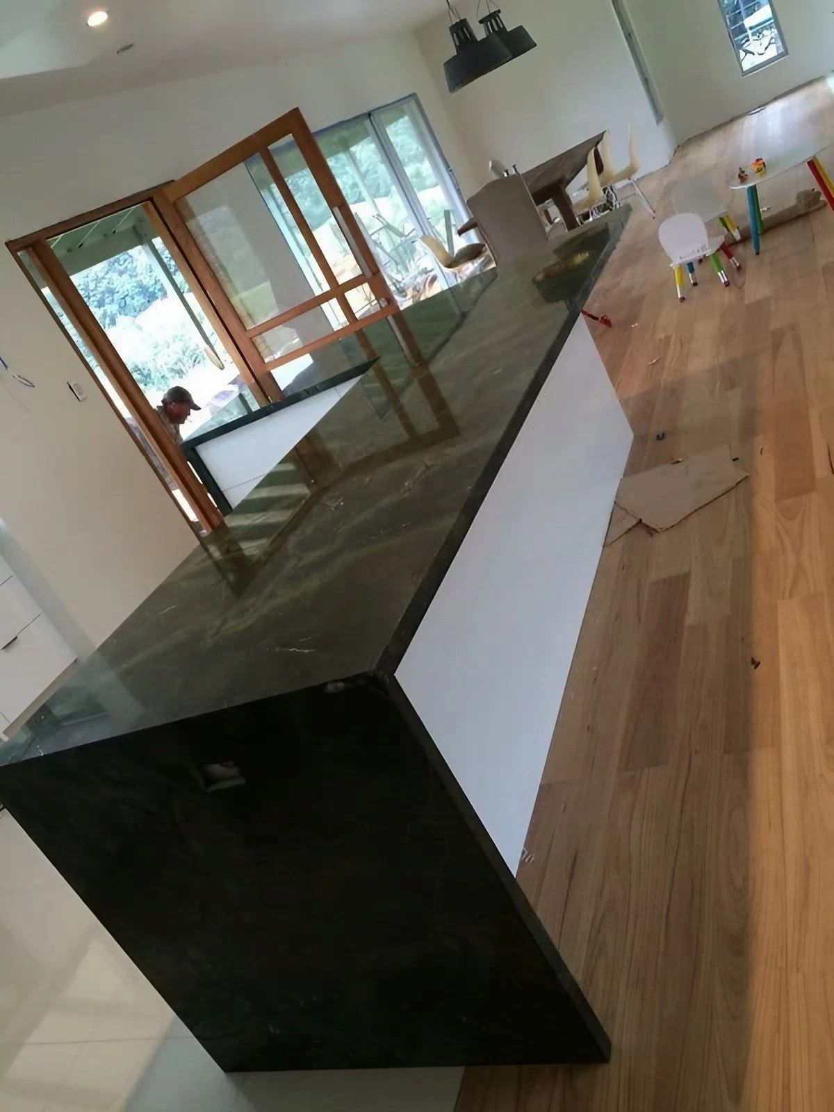 A Kitchen with A Black Counter Top and Wooden Floors — Sheridan Stone Aust in Coffs Harbour, NSW