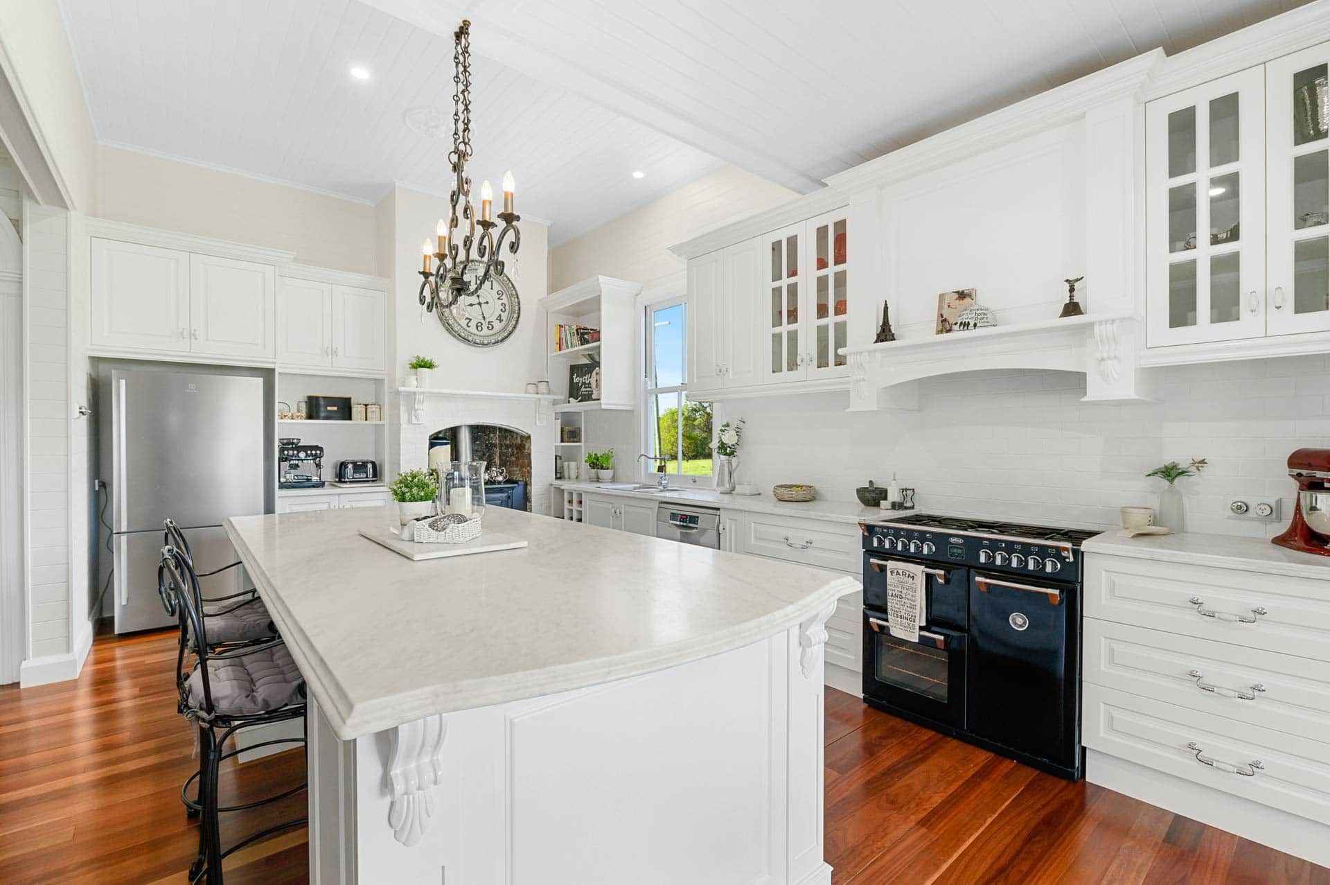 A Kitchen with White Cabinets, Black Appliances, and A Large Island — Sheridan Stone Aust in Port Macquarie, NSW