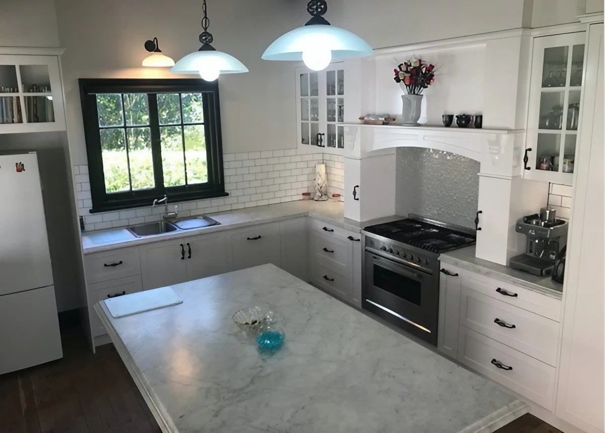 A Kitchen with White Cabinets and A Large Island in The Middle — Sheridan Stone Aust in Ballina, NSW