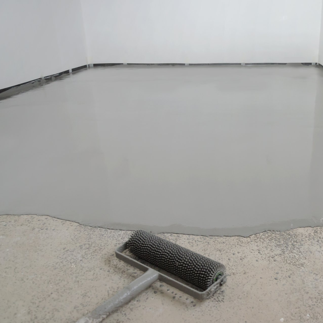 A roller is sitting on top of a concrete floor.
