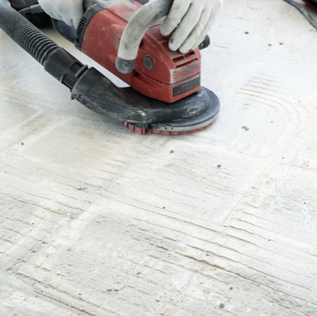 A person is using a sander on a white tile floor