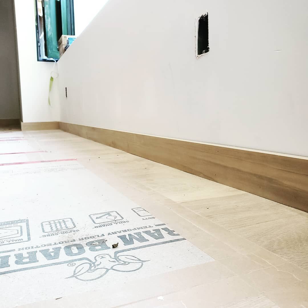 A room with a wooden floor and a white wall.