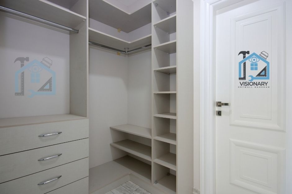 Small grey walk-in wall closet idea with cubbies and custom drawers for master bedroom