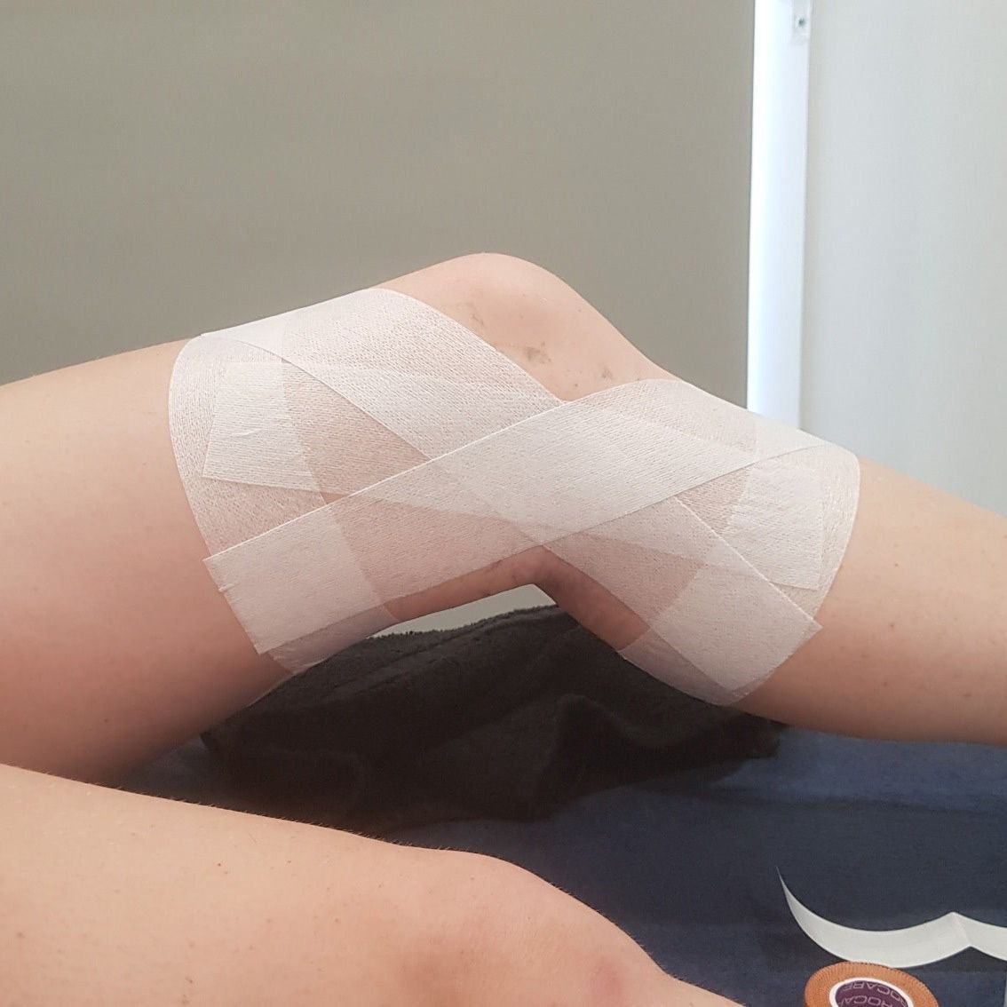 Person is Laying on a Bed With a Bandage on Their Knee — Return to Performance Physiotherapy in Epsom, VIC