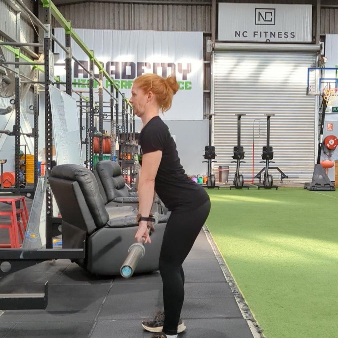 Woman is Doing Exercises in a Gym With a Sign That Says NC Fitness — Return to Performance Physiotherapy in Epsom, VIC