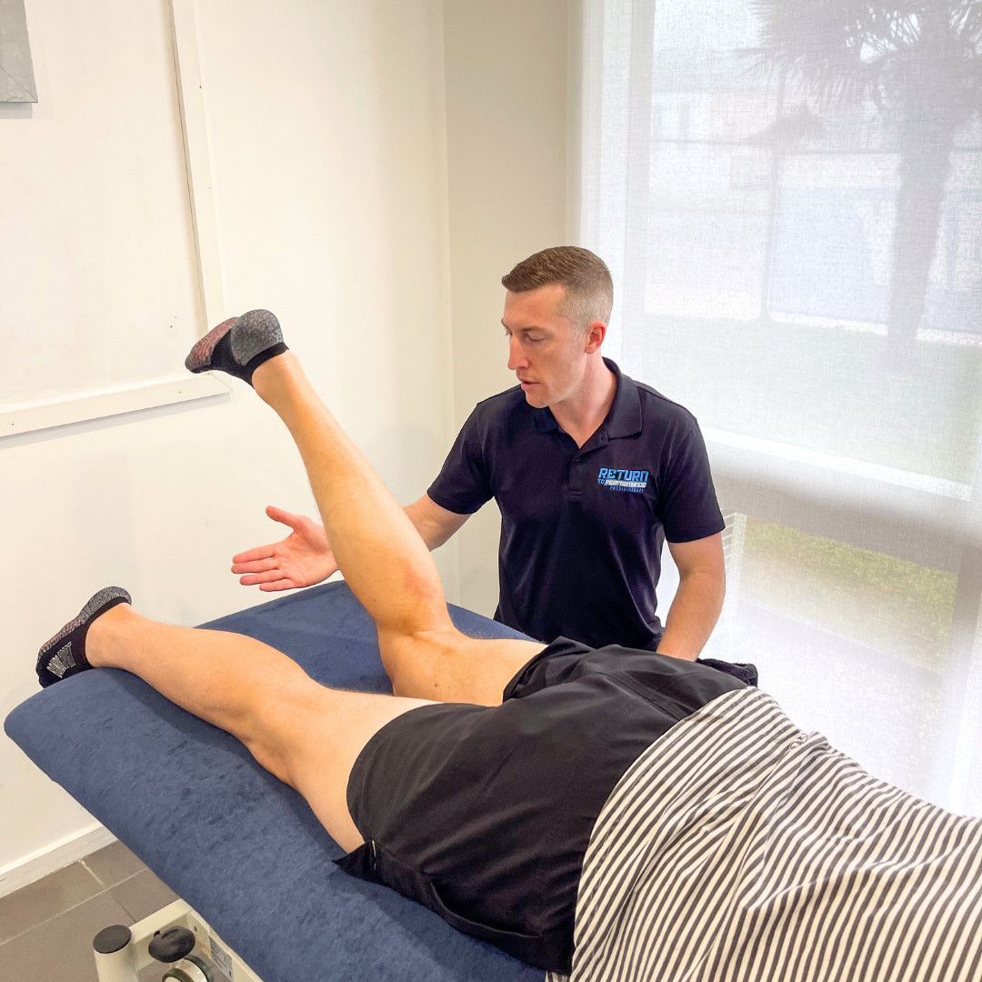 A Physical Therapist Observes a Patient Lying Face-down on a Treatment Table While Lifting ONE Leg to Test Hip Extension