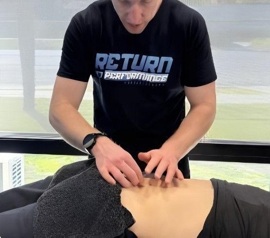 Man in Black Shirt Massaging a Person's Abdomen, Indoors — Return to Performance Physiotherapy in Epsom, VIC