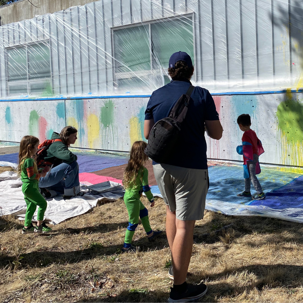 People throwing paint balloons at a scienceworks wall