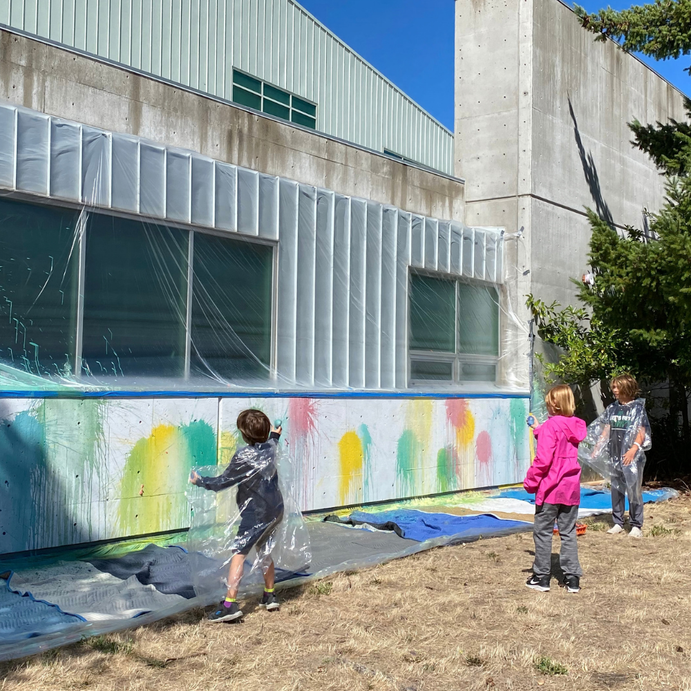 children throwing paint balloons at a scienceworks wall