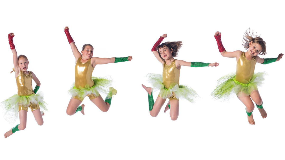 4 children in matching costumes dancing exuberantly