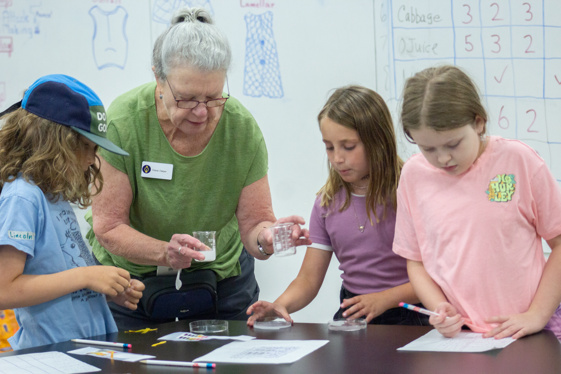 An Educator is conducting a hands-on activity with a small group of engaged children