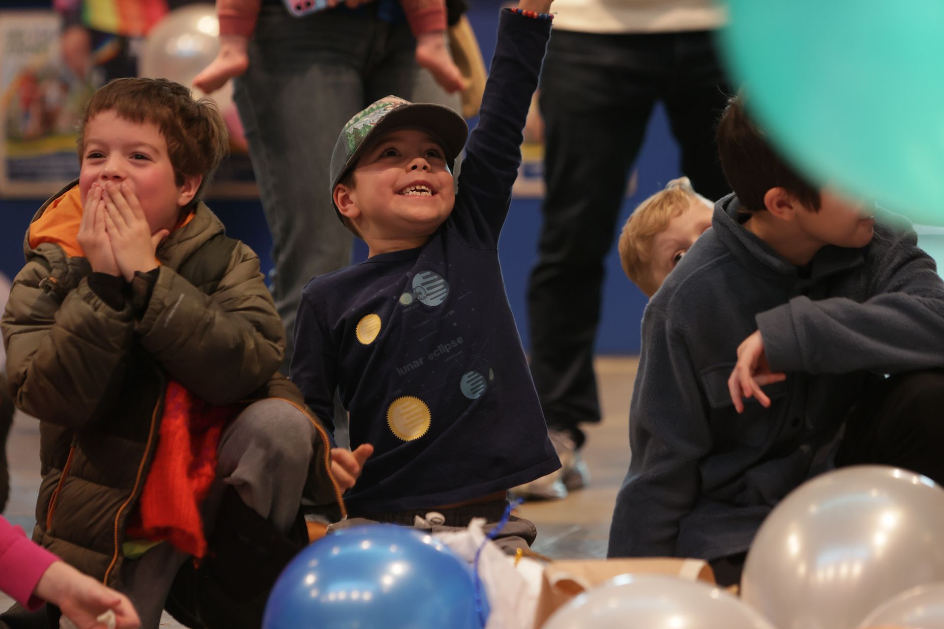 Children at an event reaching up for balloons at ScienceWorks.