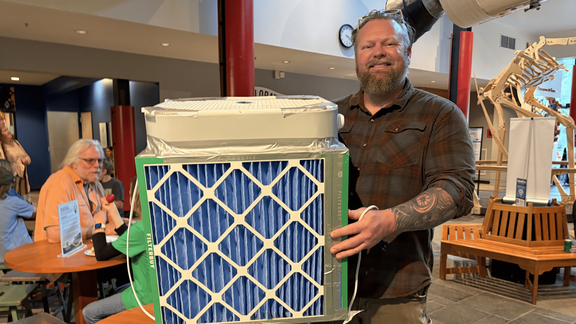 A guest shows off the DIY air filter he made in the workshop at Sparking Action