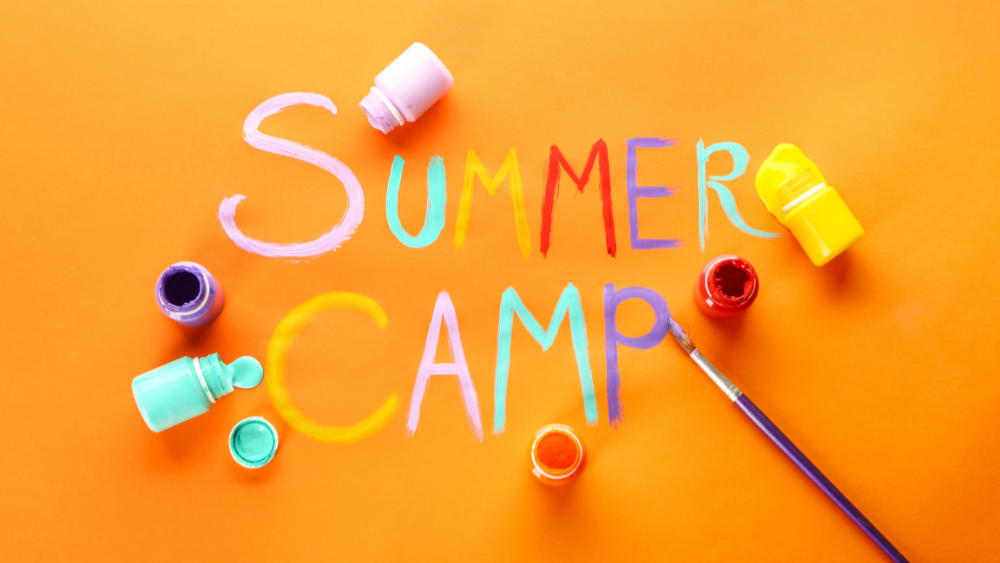 the words summer camp painted on an orange background with small paint pots and brushes scattered around