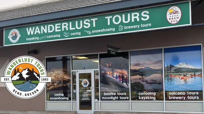 Wanderlust Tours storefront with green sign and windows advertising tours, kayaking, and brewery tours