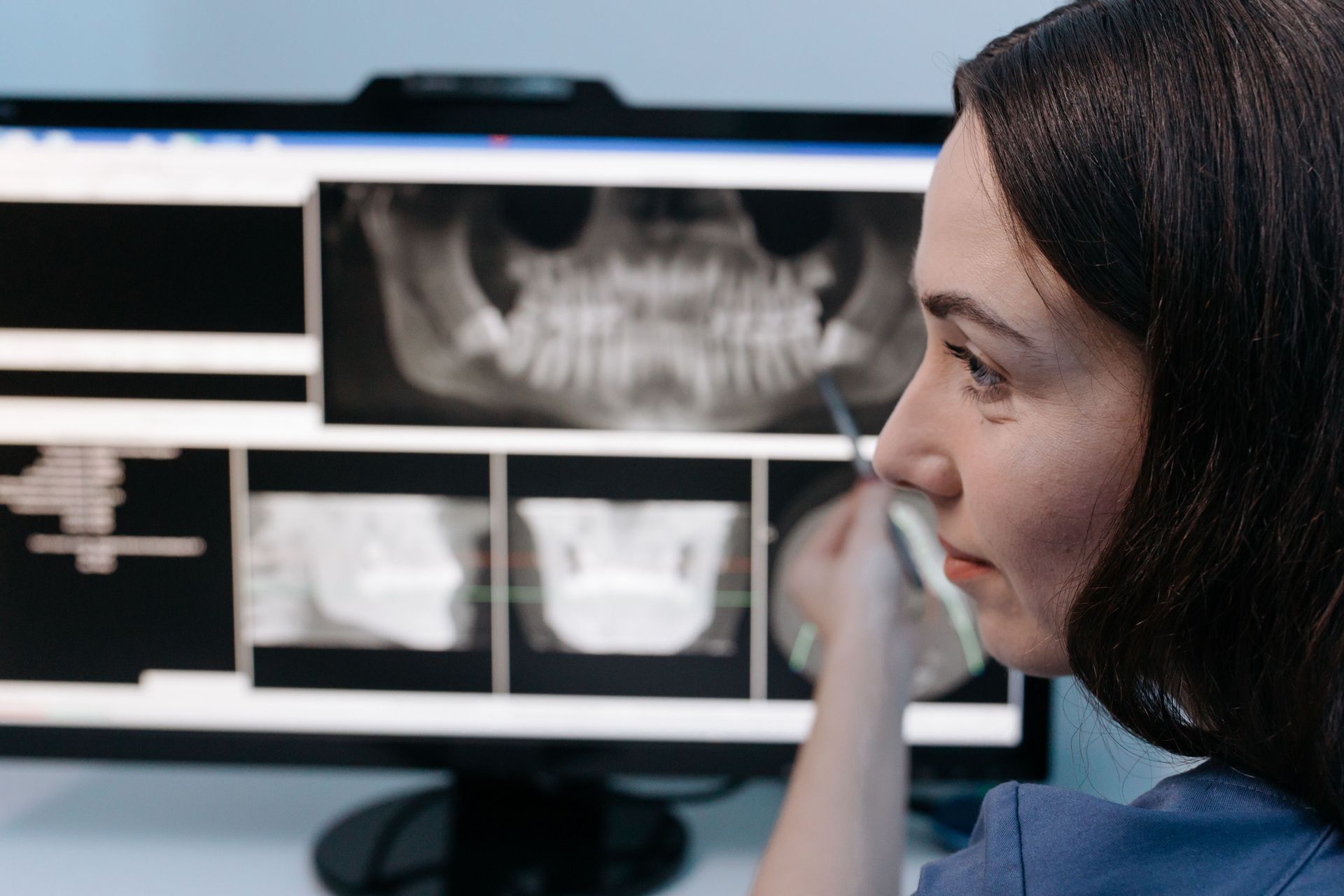 Dentist reviewing AI technology tools for scheduling imaging and patient communication in a dental office