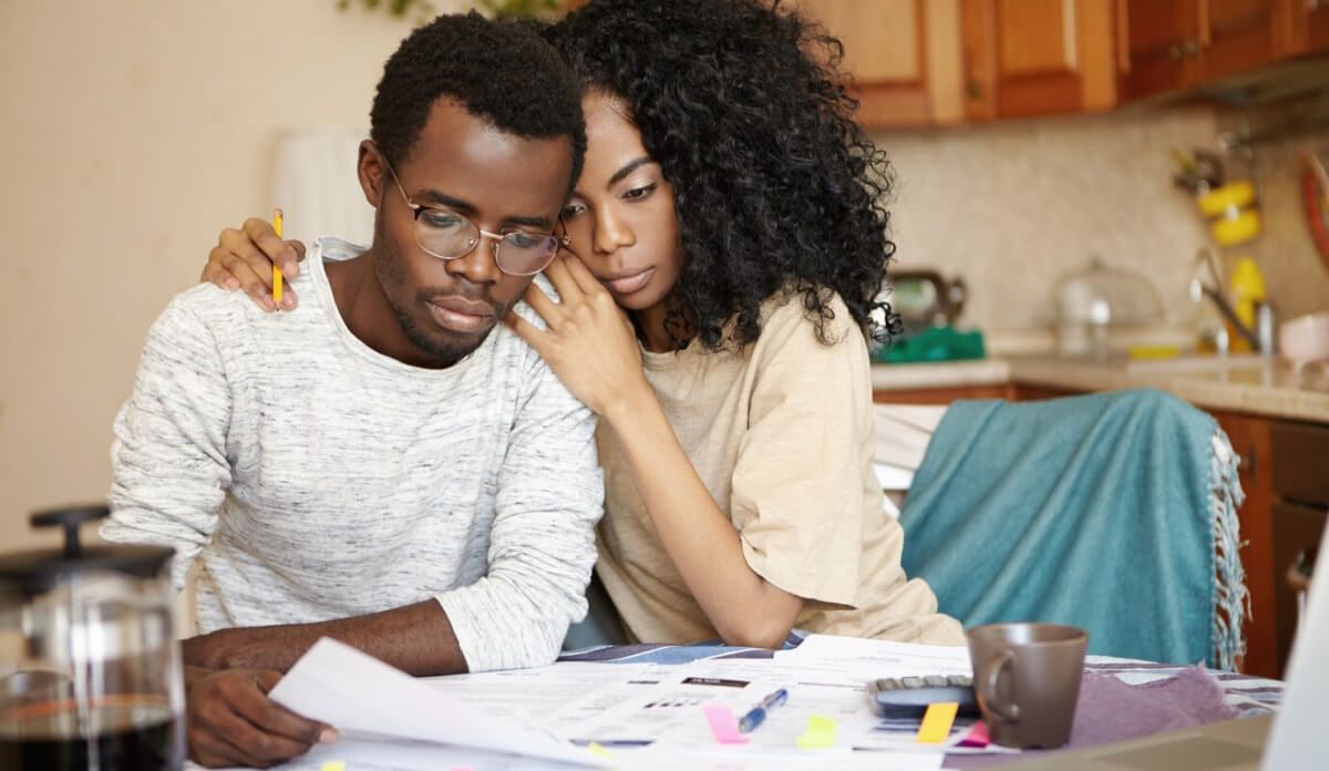 A man and a woman are sitting at a table looking at papers.