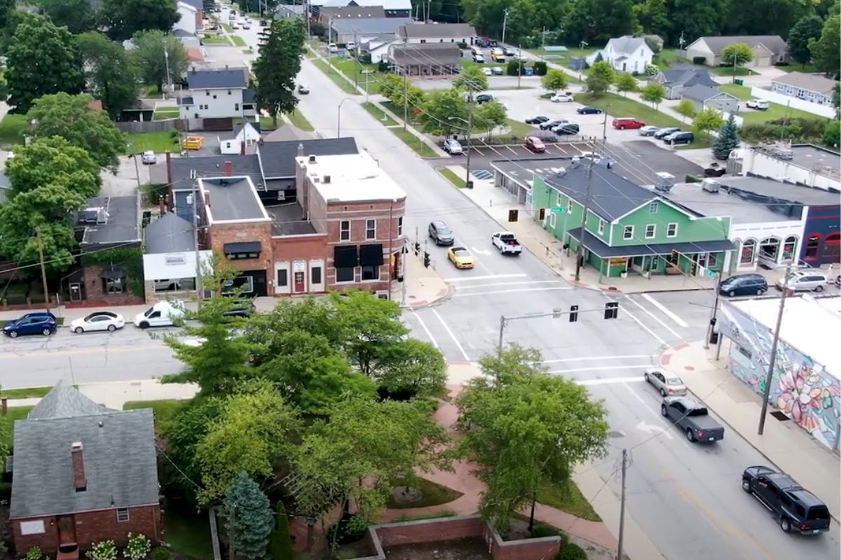 An aerial view of a small town with a green building in the middle