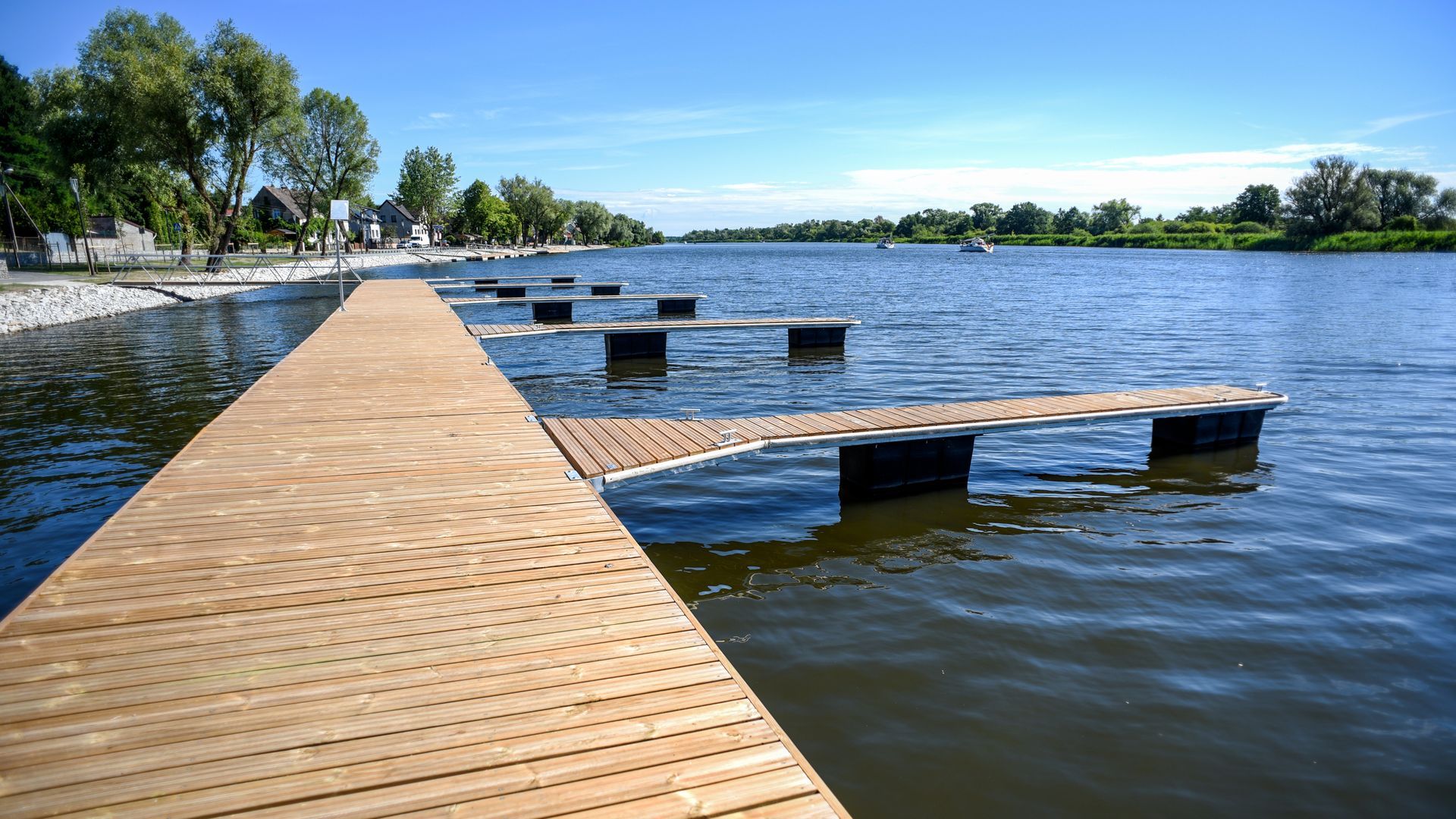 Wooden dock extending into a calm blue lake on a sunny day