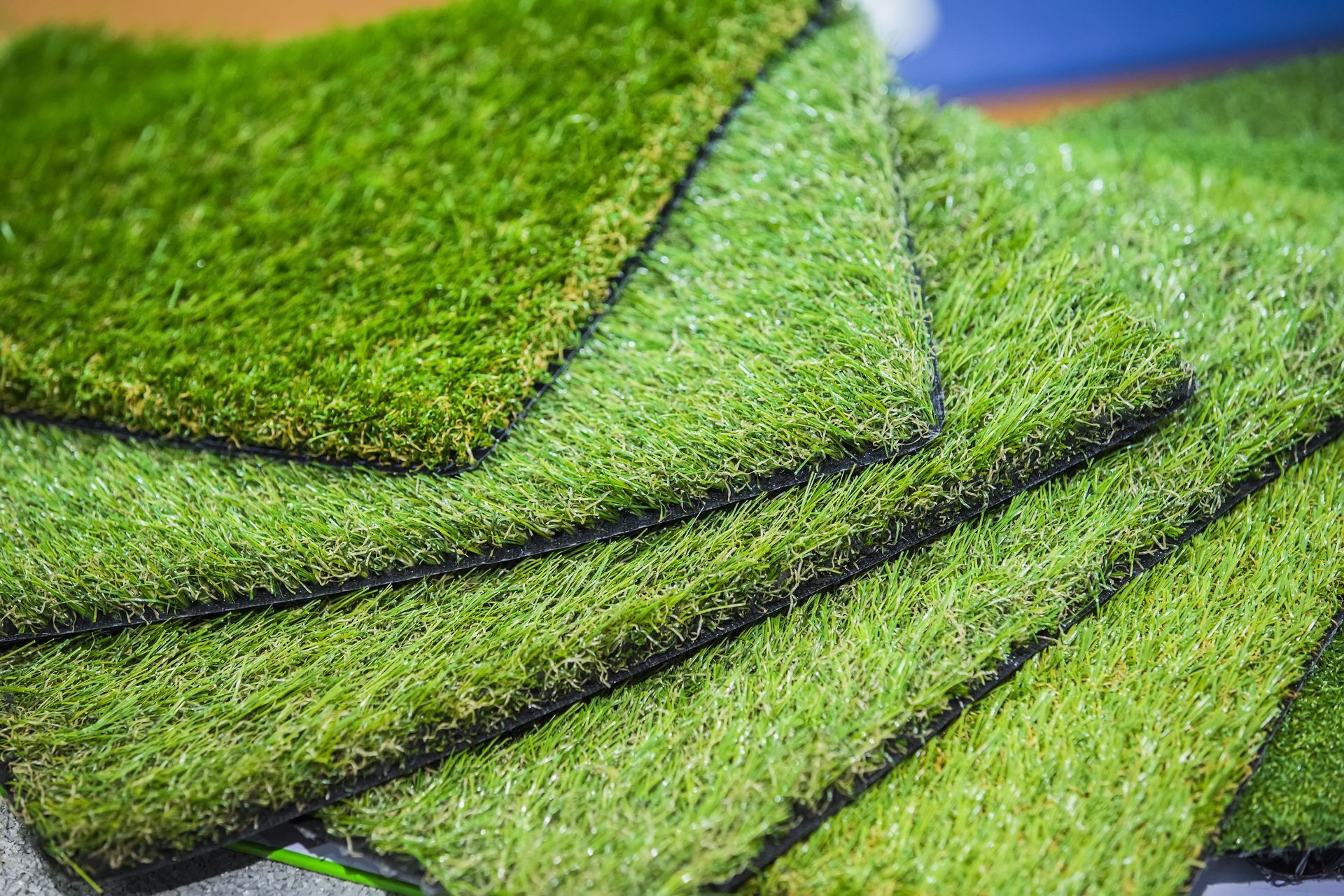 Close-up of layered green moss or felt strips with dark seams on a surface